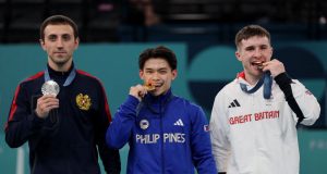 Carlos Yulo biting medal