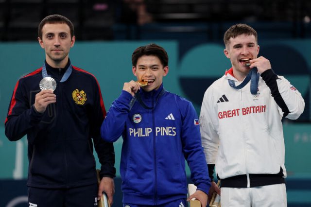 Carlos Yulo biting medal