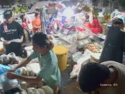 Spotted: Manila market vendor falls over while standing on bucket to hang stock