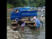 Truck floats on makeshift ferry using two wooden boats to cross river in Rizal